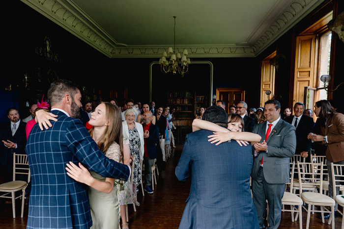 Guests hug grooms after ceremony