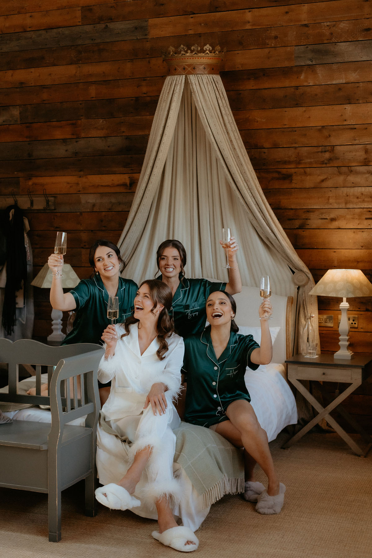 Bride and bridesmaids raising glasses while getting ready together at The Byre at Inchyra in Perthshire.