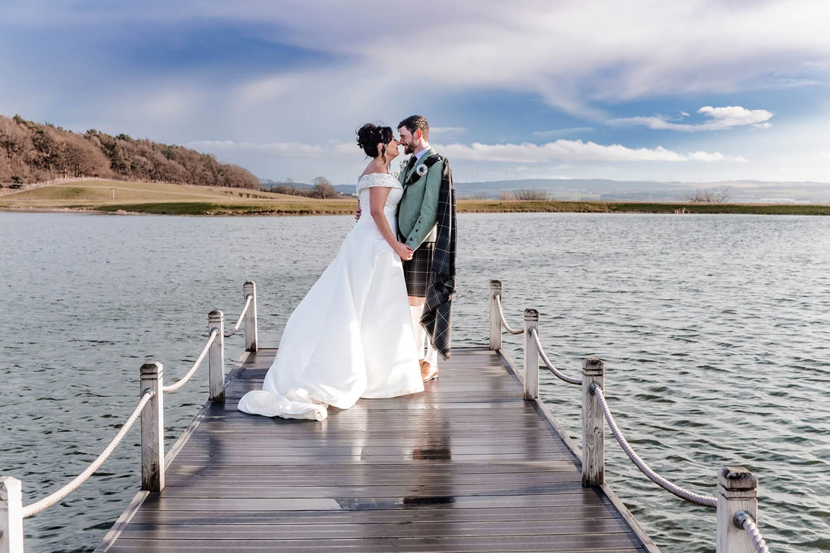 Bride and groom on the jetty at The Vu beside Ballencrieff Reservoir in West Lothian