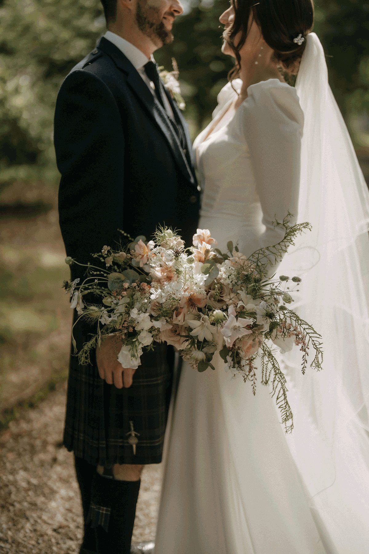 Bride and groom facing each other, bride holding flowers