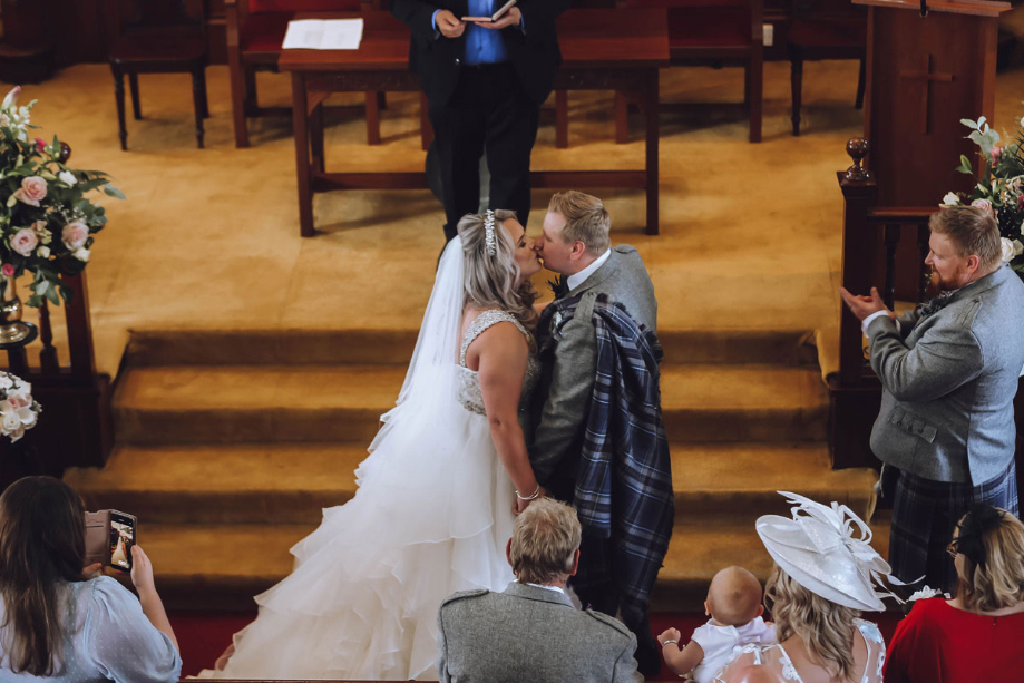 A Bride And Groom Kissing After Wedding Ceremony In Eaglesham Parish Church