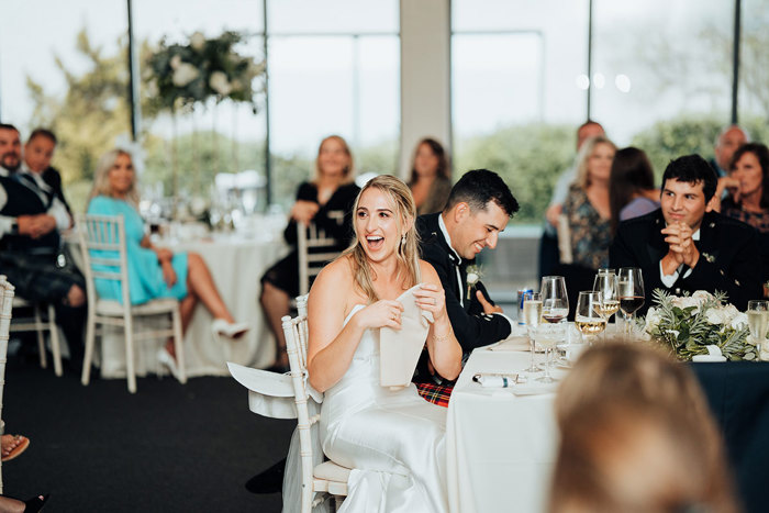  A person in a white dress sitting at a table with a person in a tuxedo.