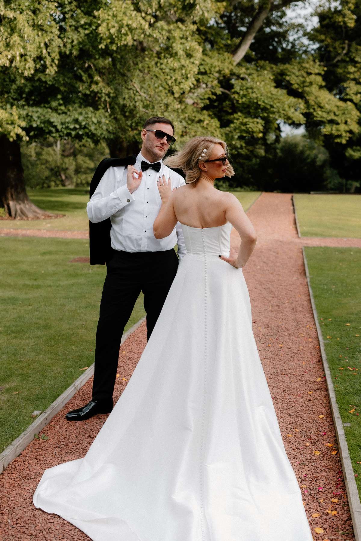 Kara and Rory pose in sunglasses for relaxed wedding portraits in the gardens at Prestonfield House in Edinburgh.