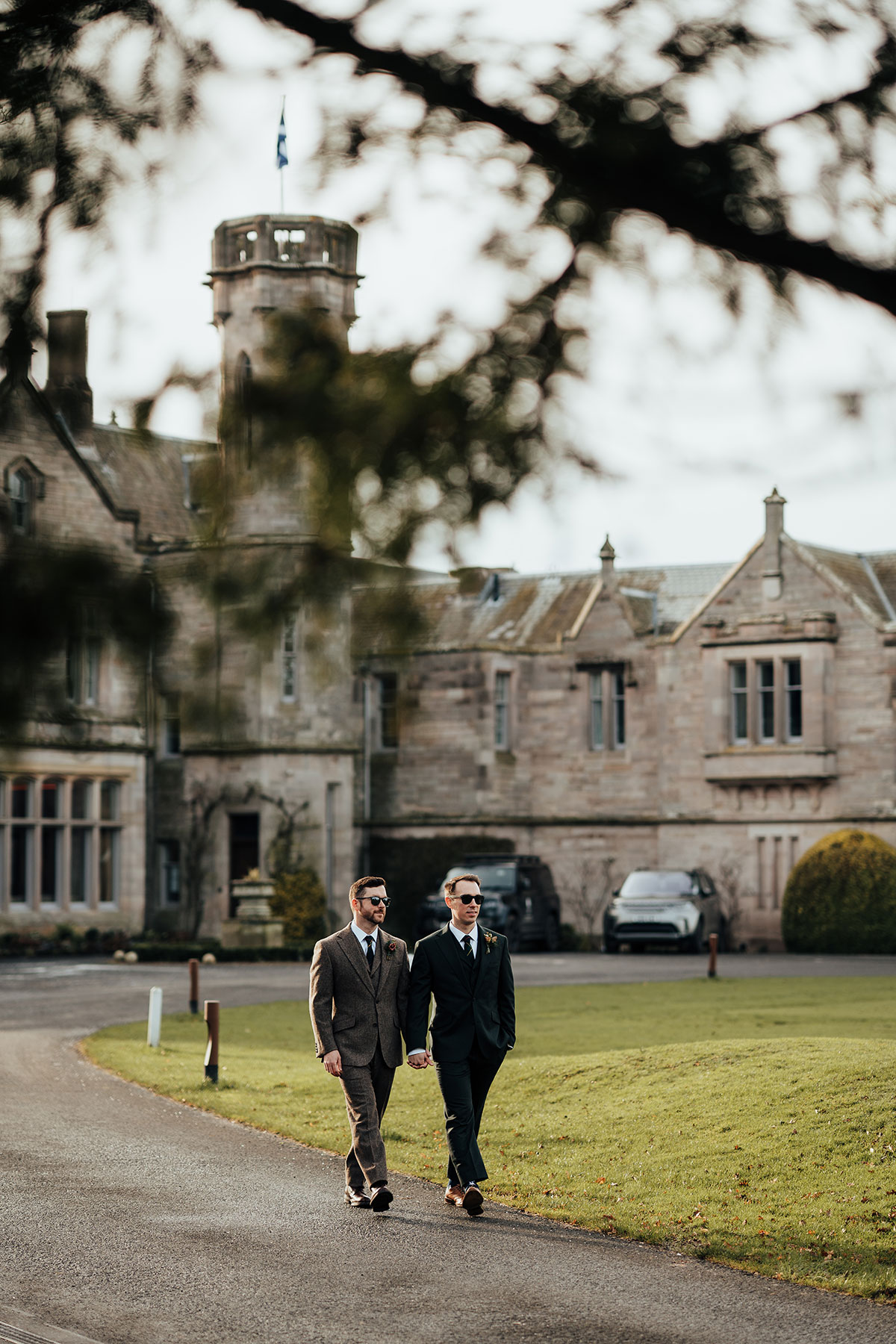 The couple stroll through the grounds of Schloss Roxburghe with the house behind them