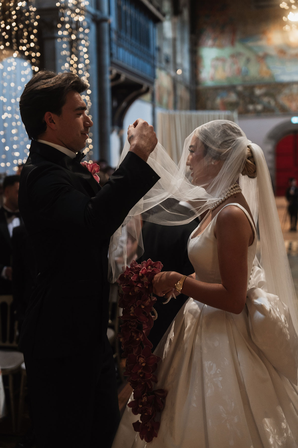 Groom lifting the bride’s veil during an emotional wedding ceremony moment at Mansfield Traquair