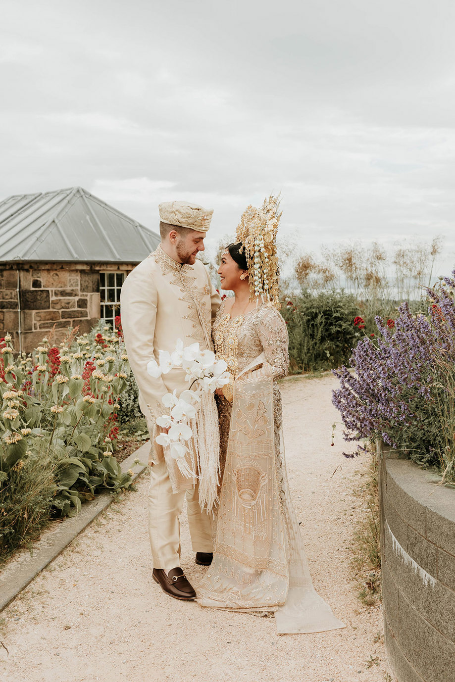 bride and groom smiling at signet library in edinburgh with indonesian wedding outfits