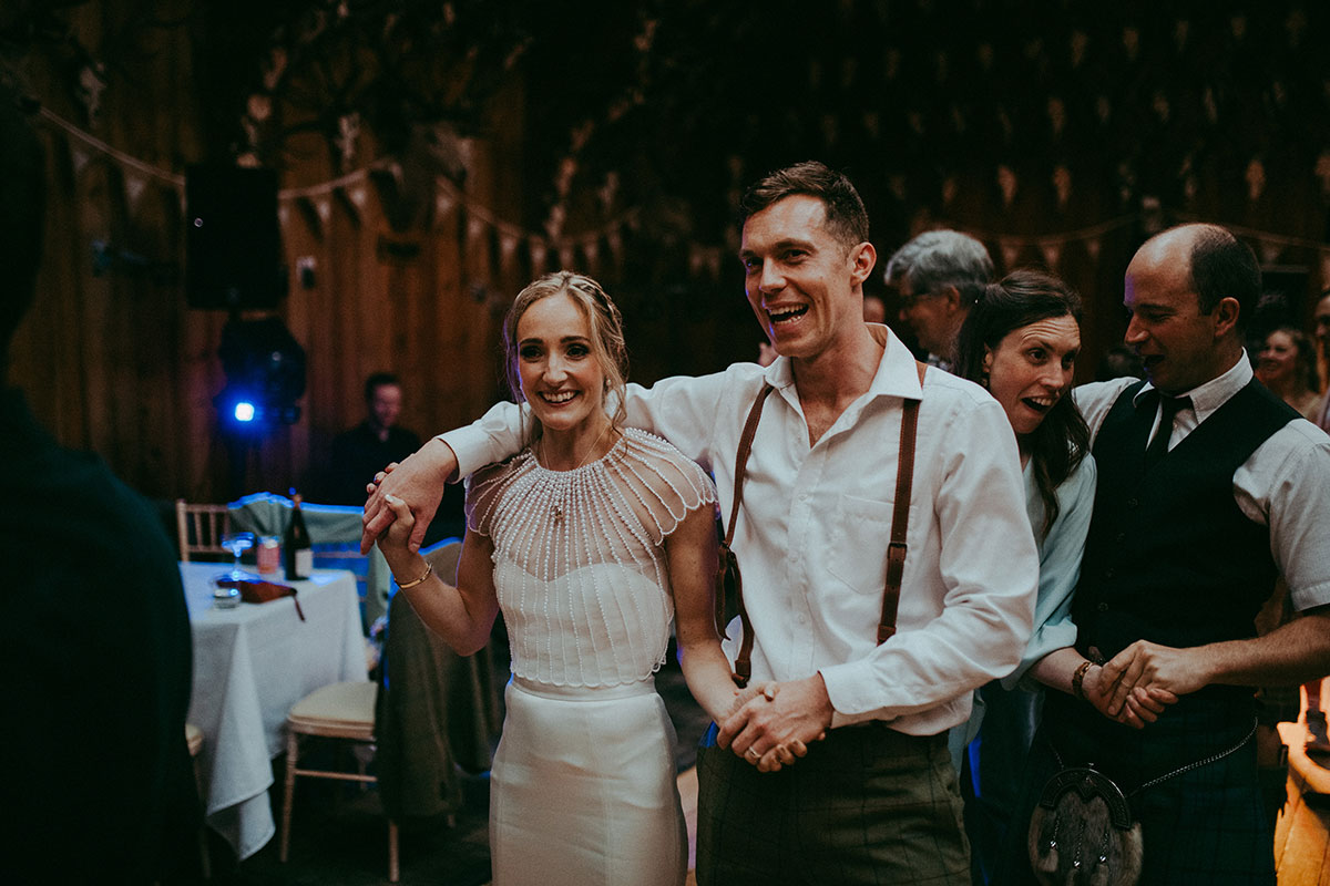 Bride and groom ceilidh dancing at wedding at mar lodge