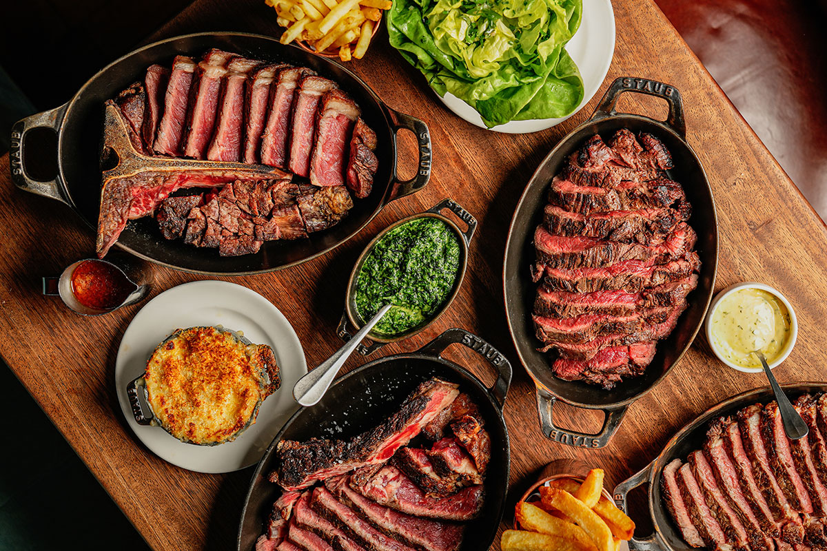 Sharing-style steak dishes with fries and sides at Hawksmoor Edinburgh restaurant.