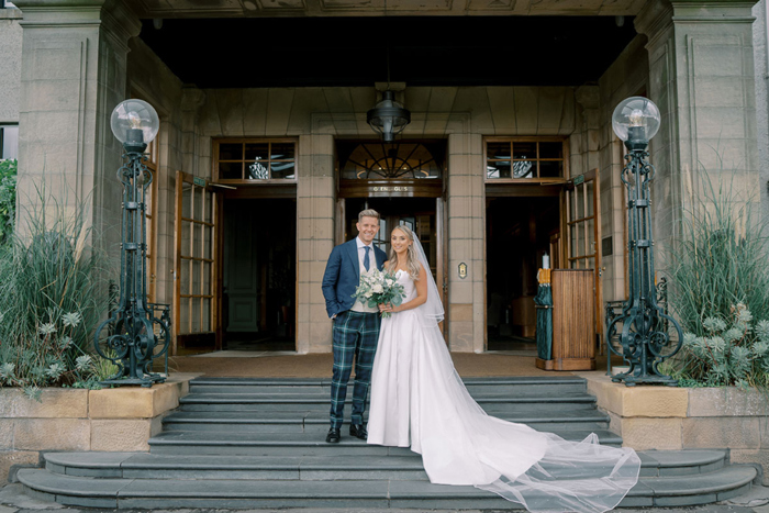 Bride and groom on the stairs outside Gleneagles Hotel