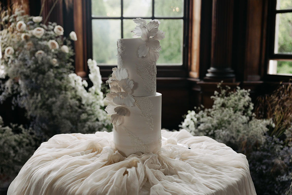 Elegant white wedding cake with floral detailing at Gilmerton House East Lothian venue
