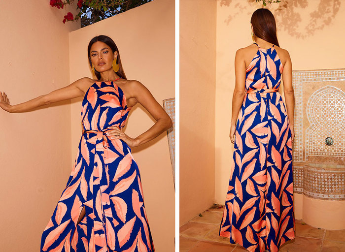 A woman wearing a long blue floaty dress with a halter neck and an orange print dress