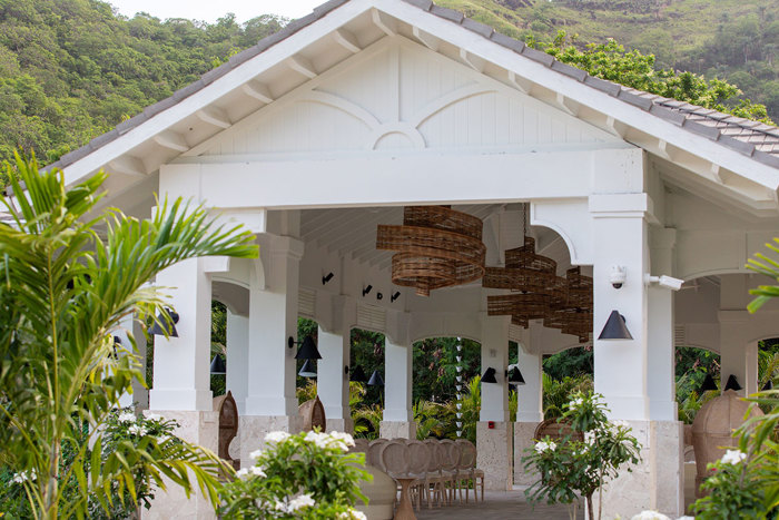 A white building with chairs and trees at Sandals Saint Vincent and Grenadines