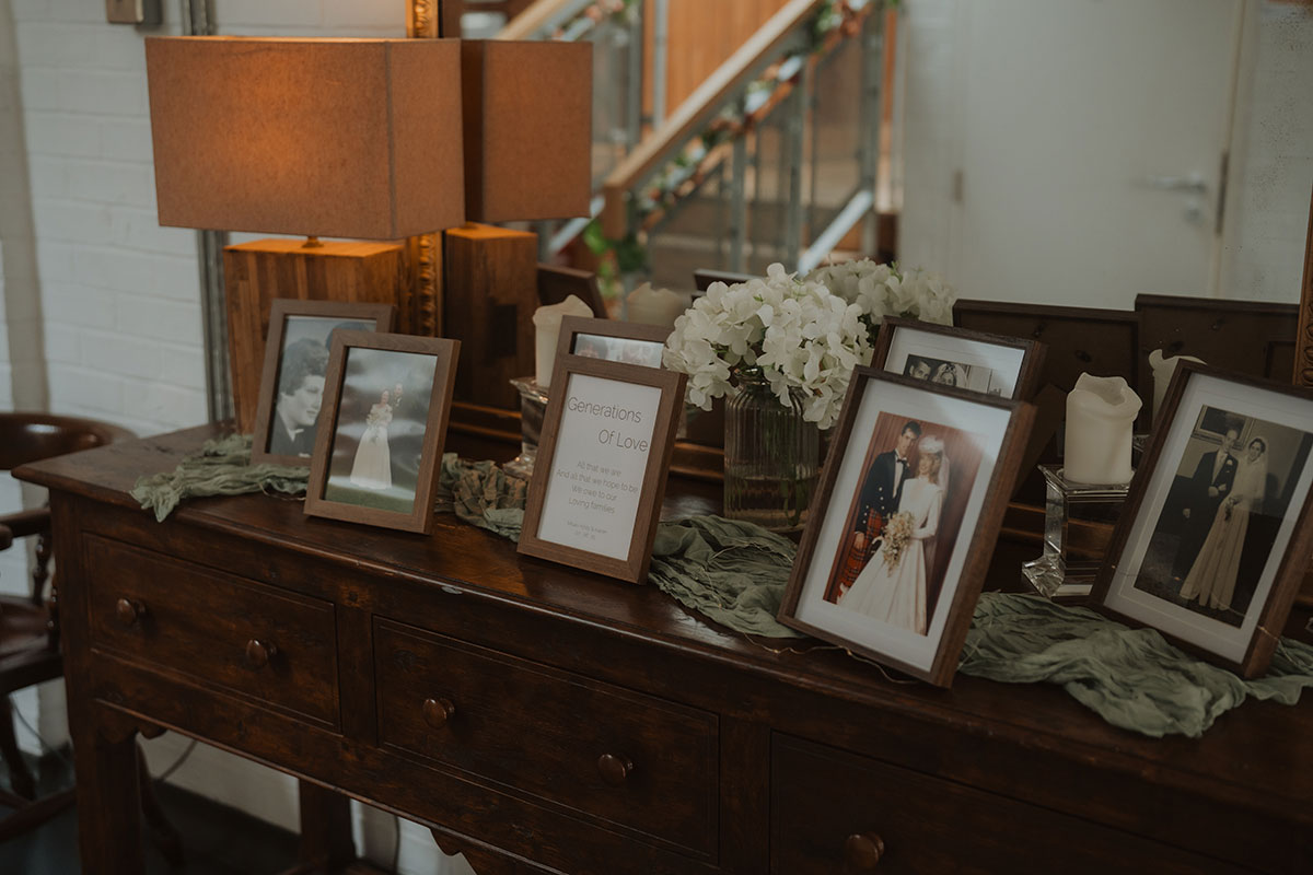 Generations of love display with framed family wedding photos styled on vintage wooden dresser