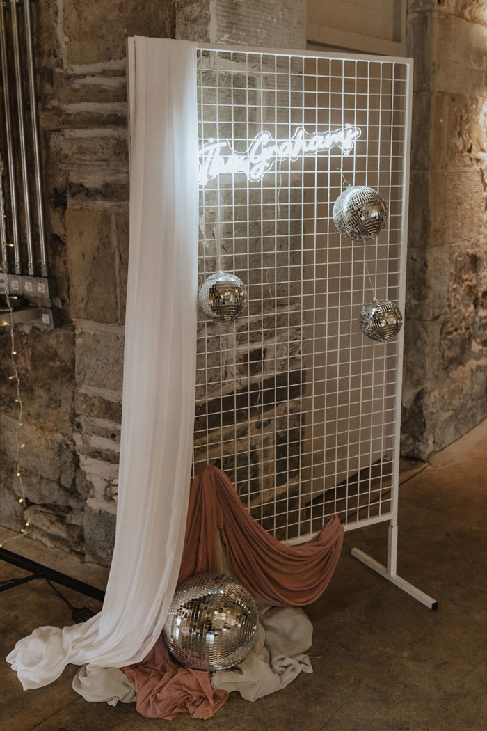 disco balls with light up sign on wall at falside mill wedding