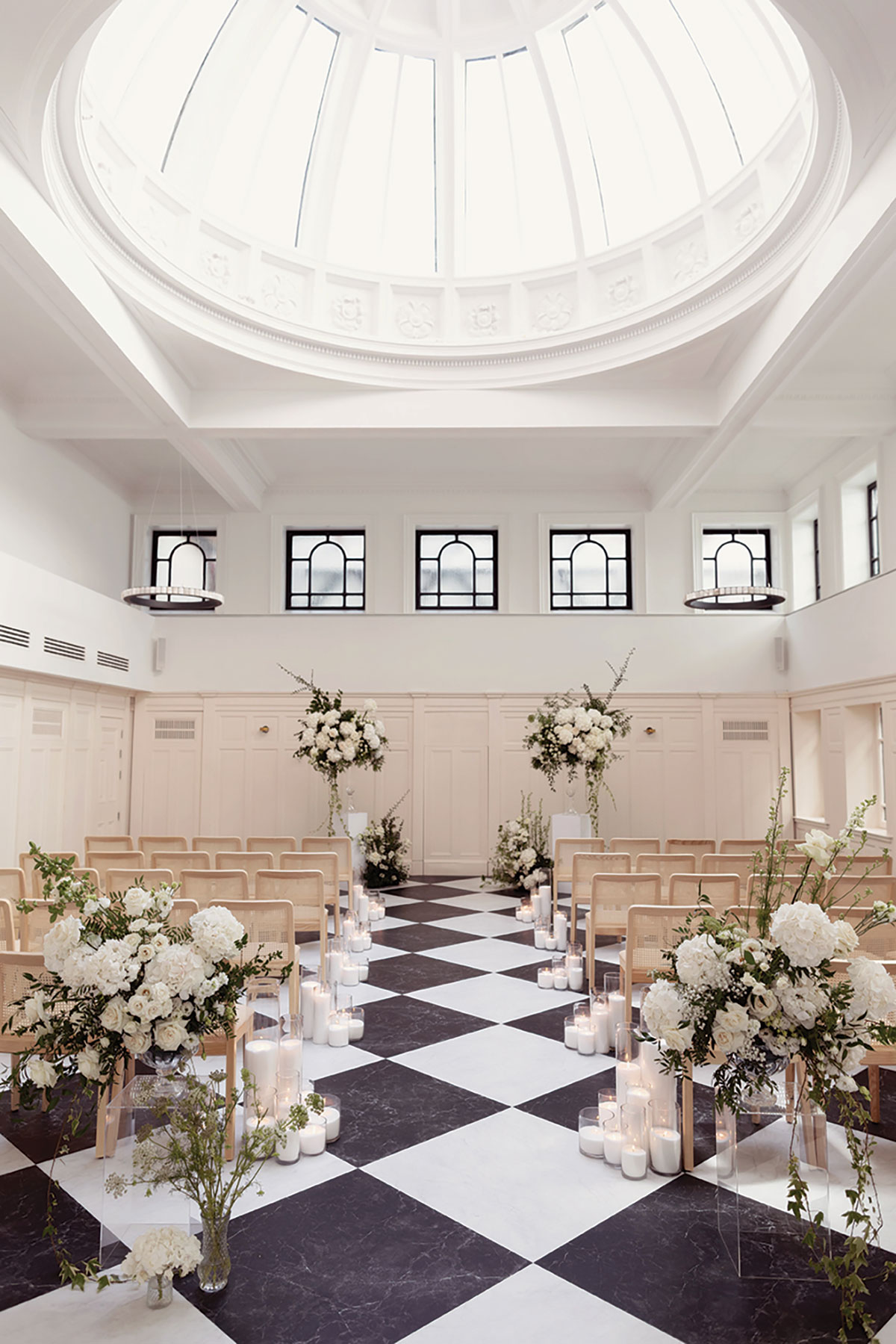 White floral wedding arrangements with greenery decorating aisle at The Collector’s Hall Glasgow