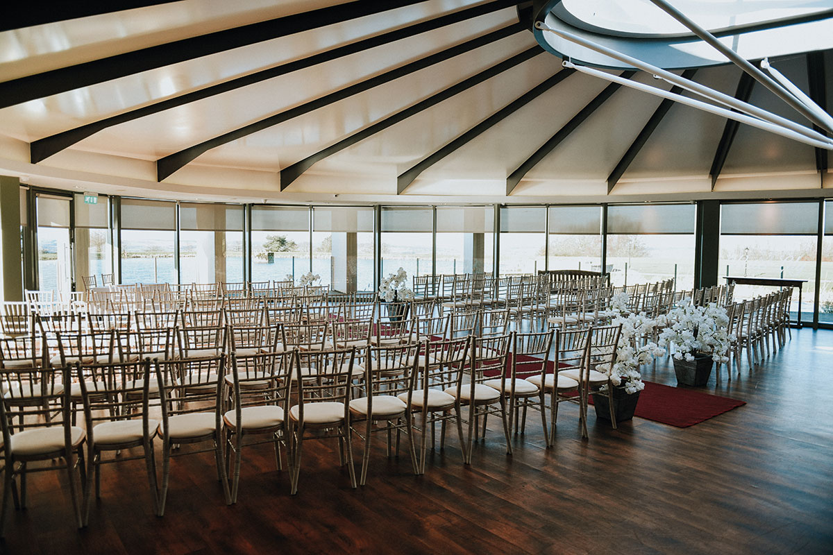 Waterlily wedding ceremony setup at The Vu in Bathgate with rows of Chiavari chairs, white flowers and reservoir views