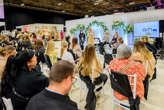 An audience watching a talk on stage with a presentation 