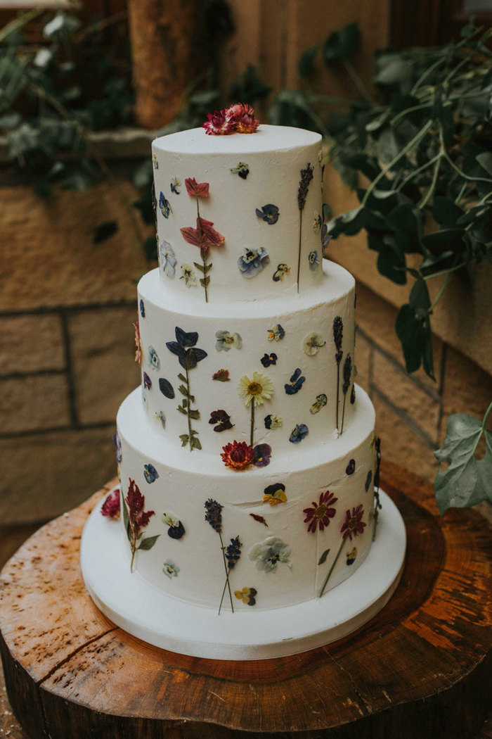 close up of wedding cake with white icing and floral details