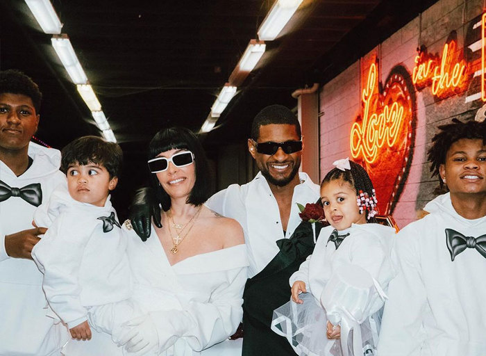 Usher and Jennifer Goicoechea on their wedding day with their four children, all wearing white.