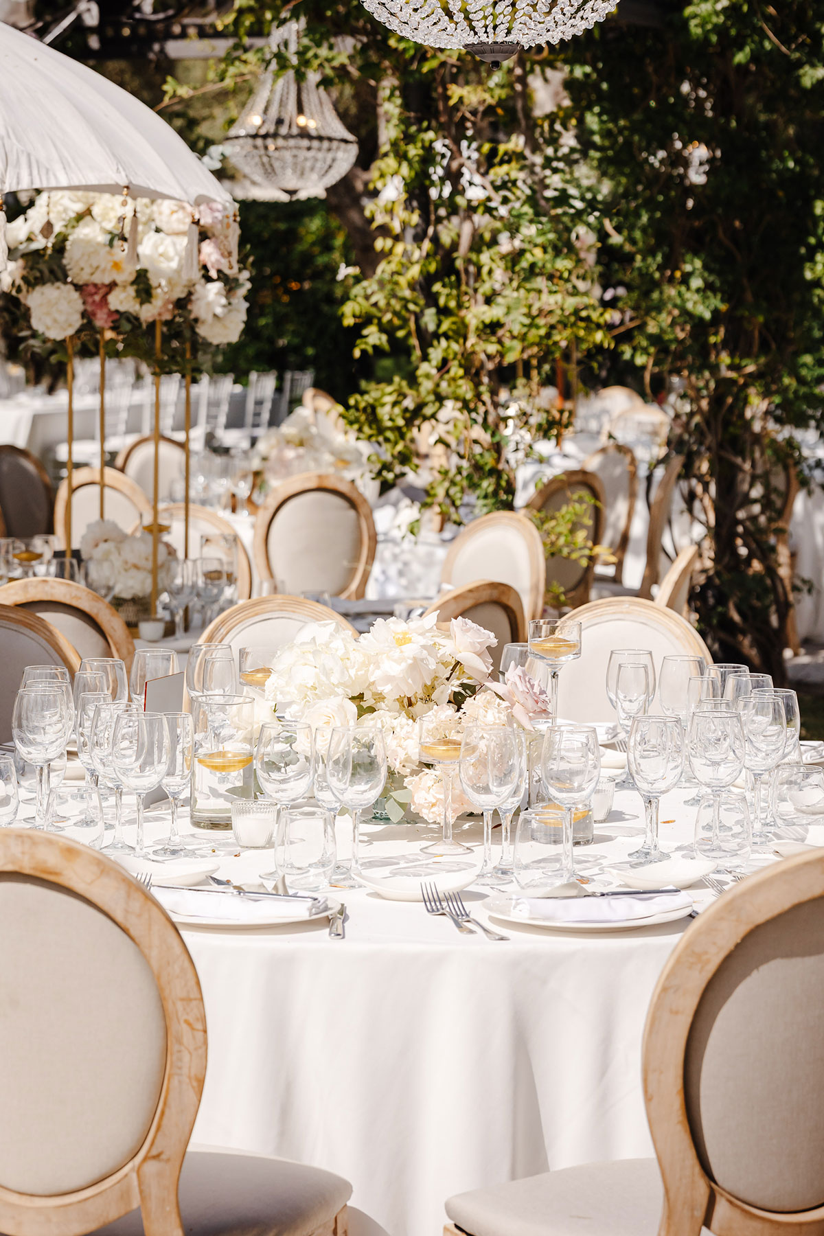 Round tables styled with ivory linens, crystal glassware and blush floral centrepieces