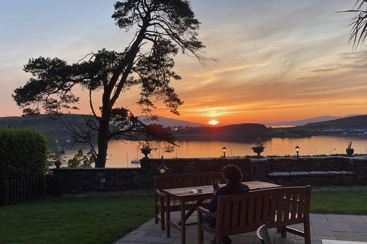 Sunset view over the water from Dungallan with garden seating and coastal landscape