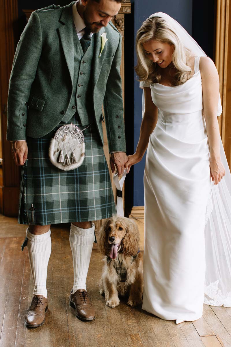 Lia and Louis pose with their cocker spaniel Bertie during their Cambo House wedding in Fife.