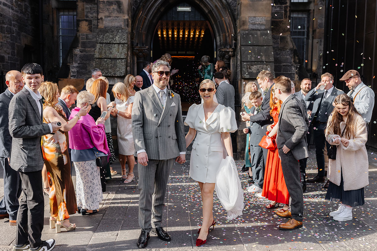 A bride, groom and wedding guests gathered outside Greyfriars Hall at Virgin Hotels Edinburgh