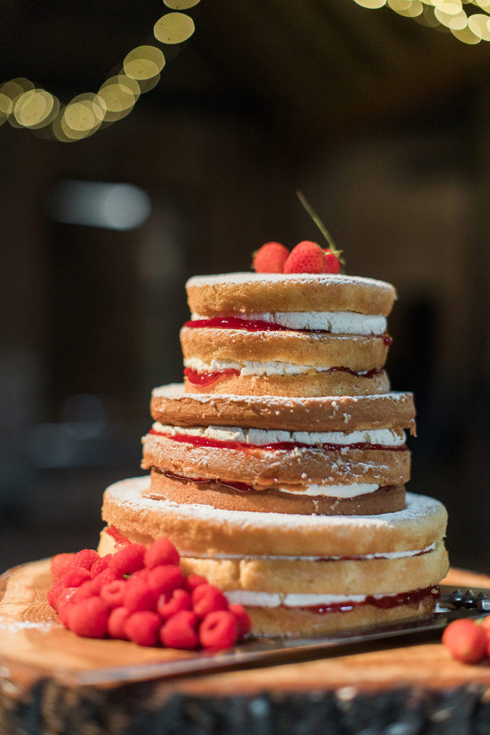 a cake comprising a tall stack of sponges with red jam and cream