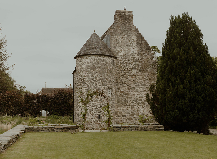 stone exterior of Kilmartin Castle and surrounding garden