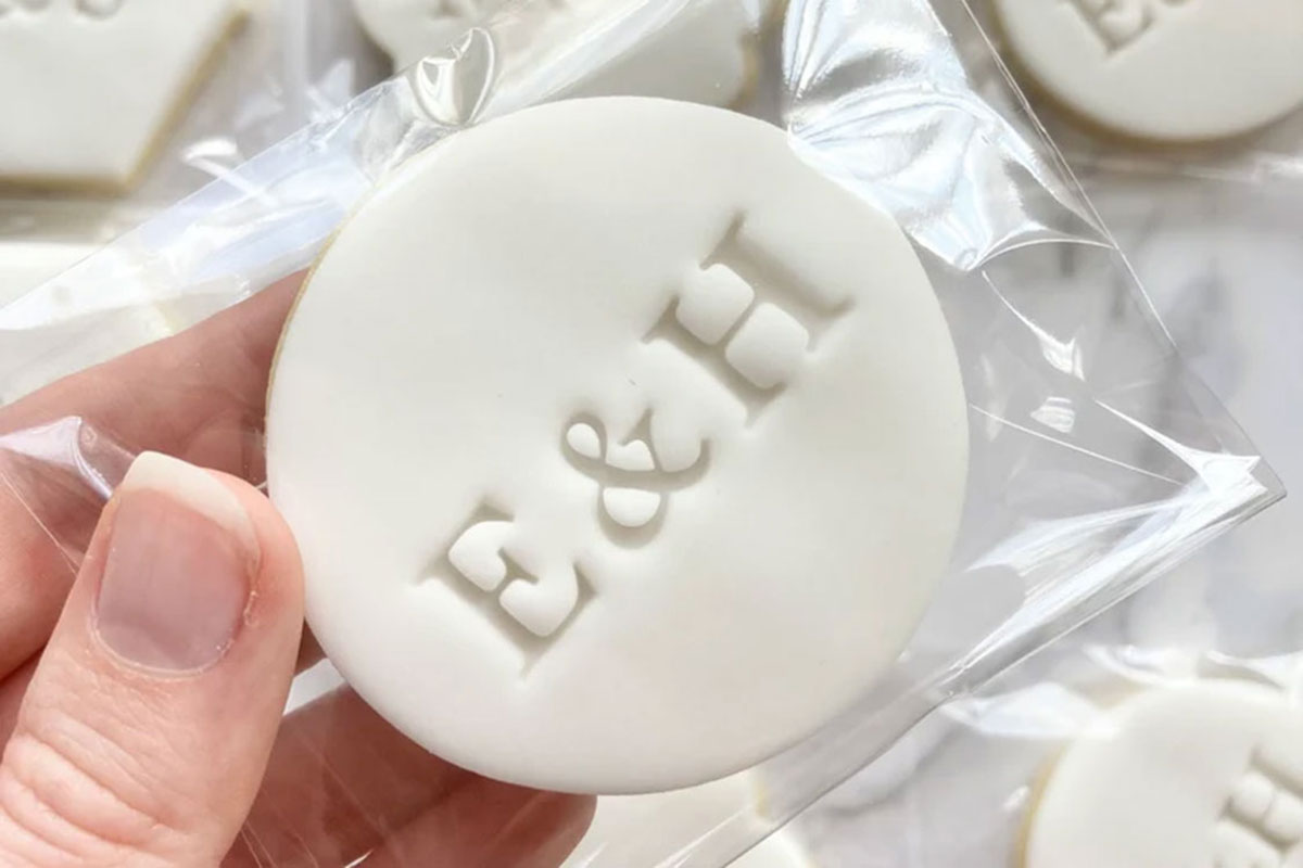 Personalised white biscuit wedding favour stamped with couple’s initials