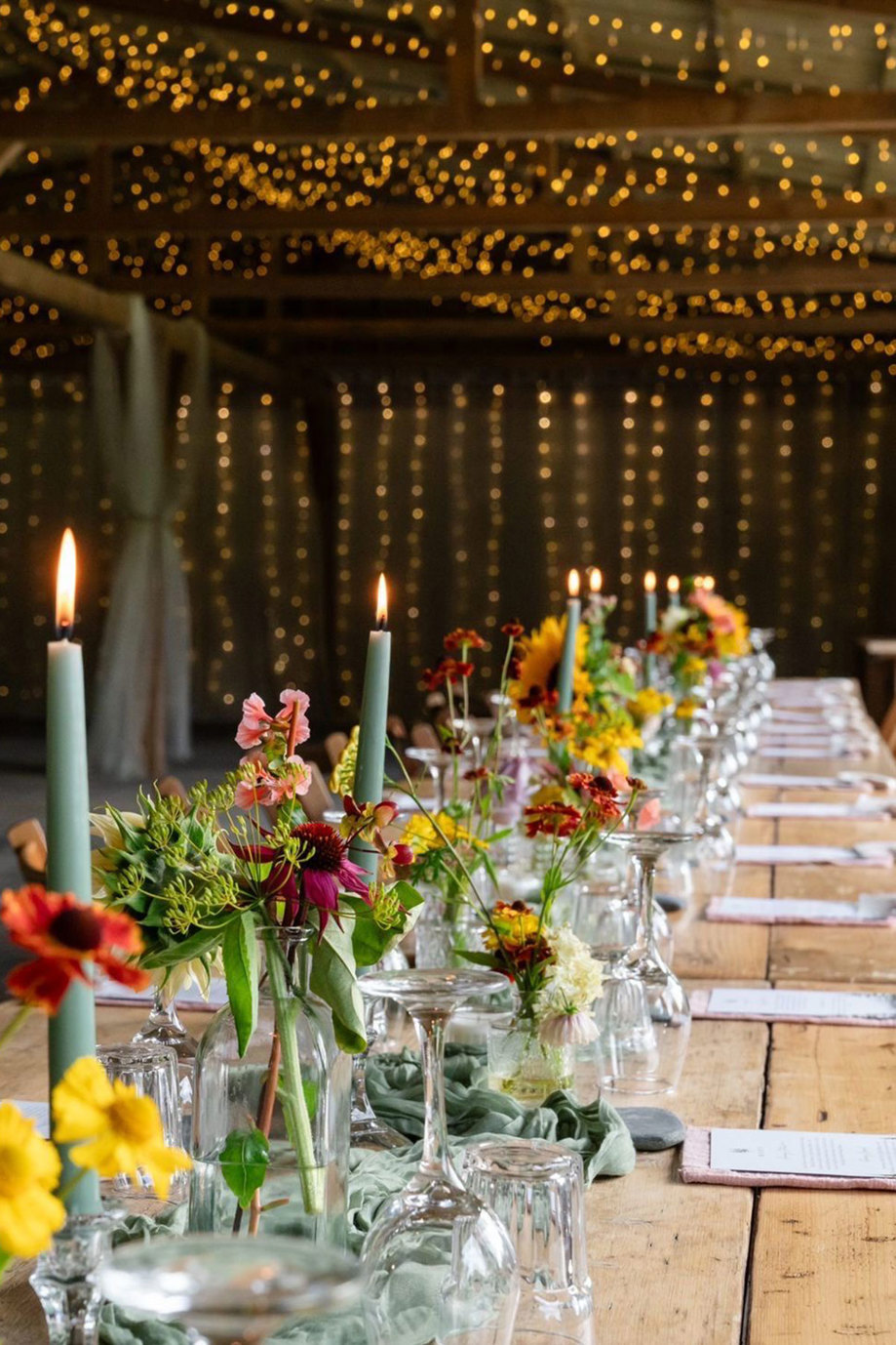 wooden table set up with colourful decorations and flowers for wedding dinner at culdees castle