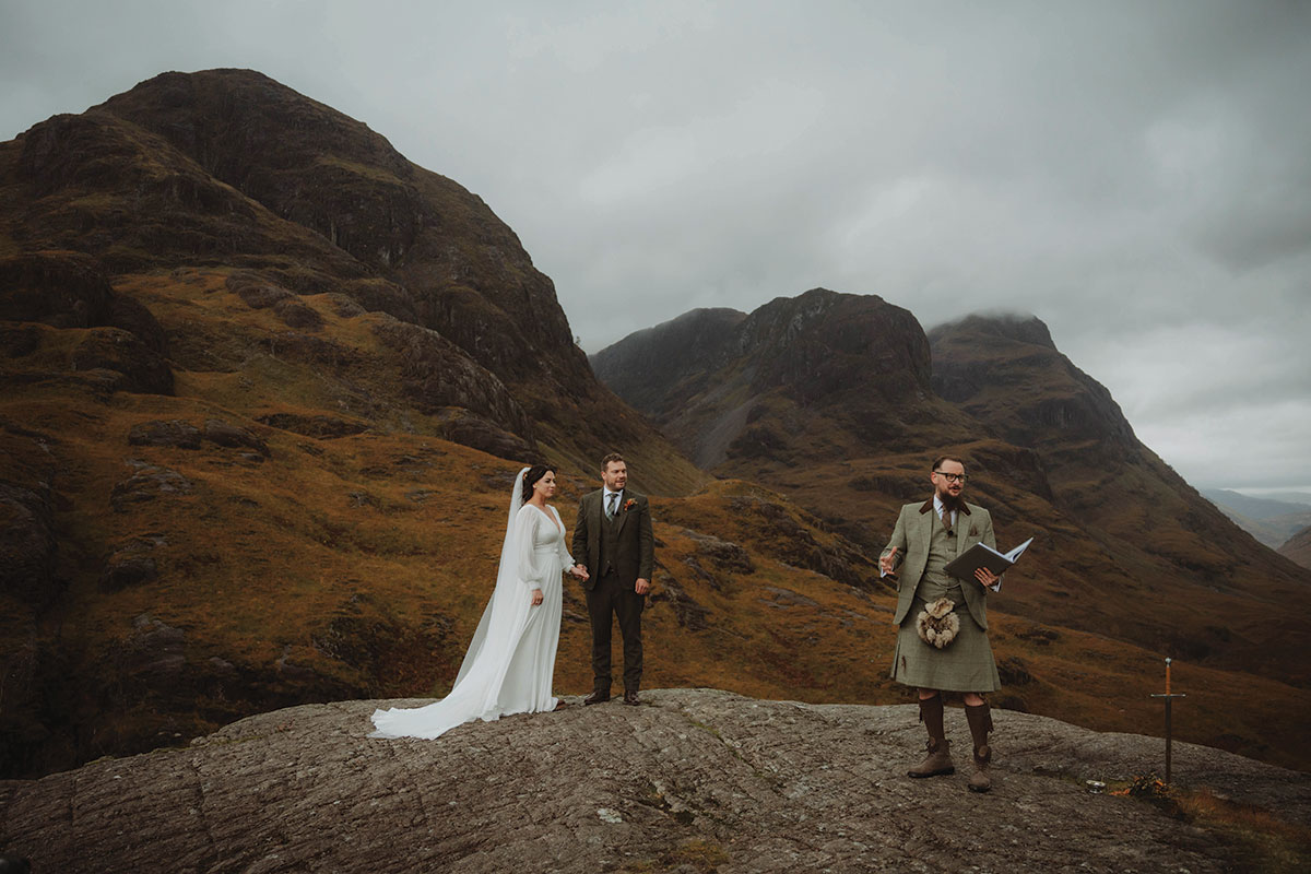 Intimate Highland elopement ceremony on a rocky viewpoint with dramatic mountain scenery