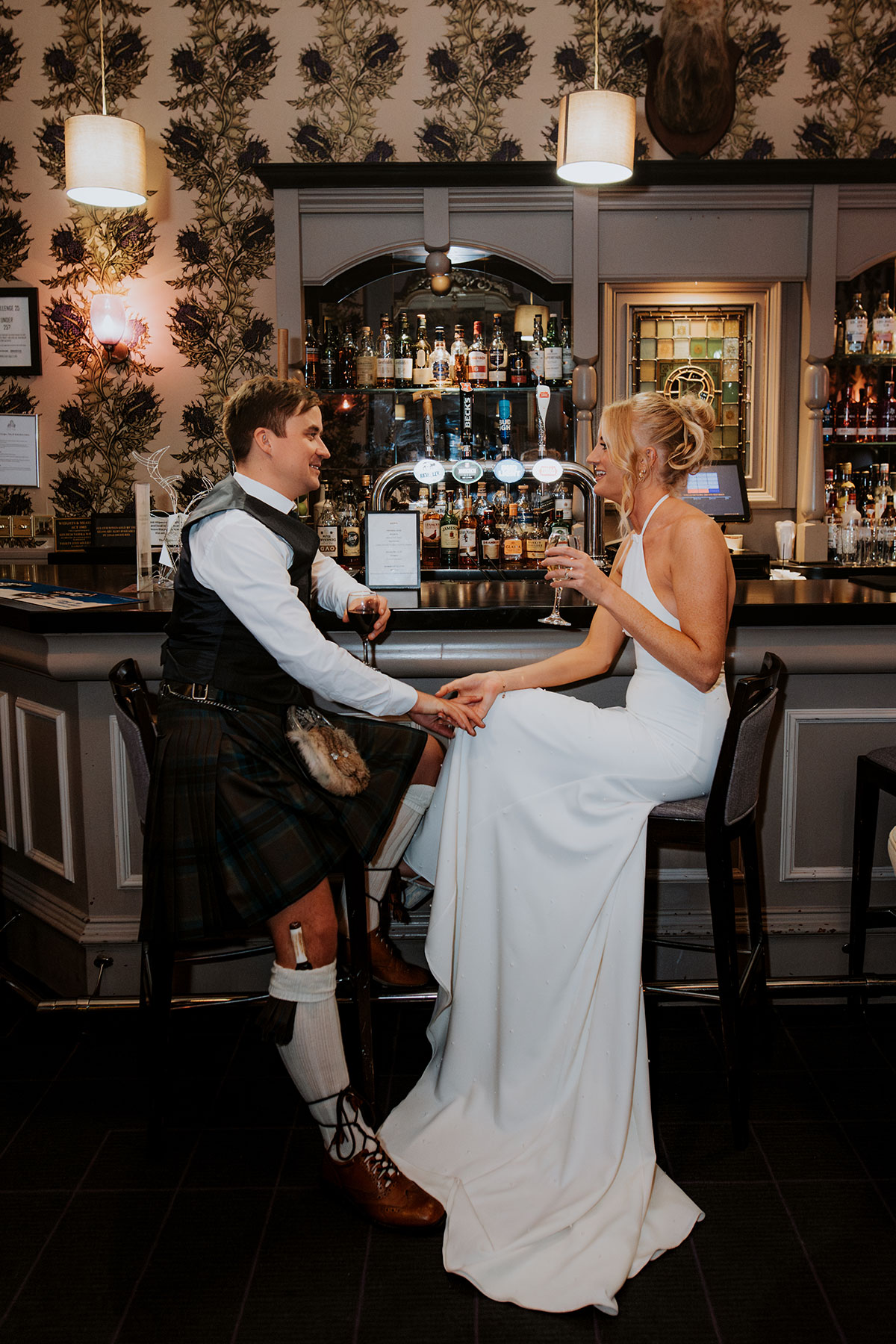bride and groom sit at the bar for a drink at wedding at Ardoe House