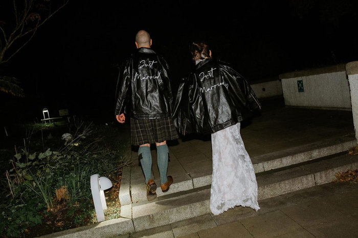 bride and groom wearing 'just married' leather jackets