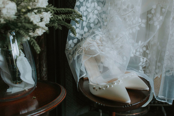 close up of pearl detailed wedding shoes and dress