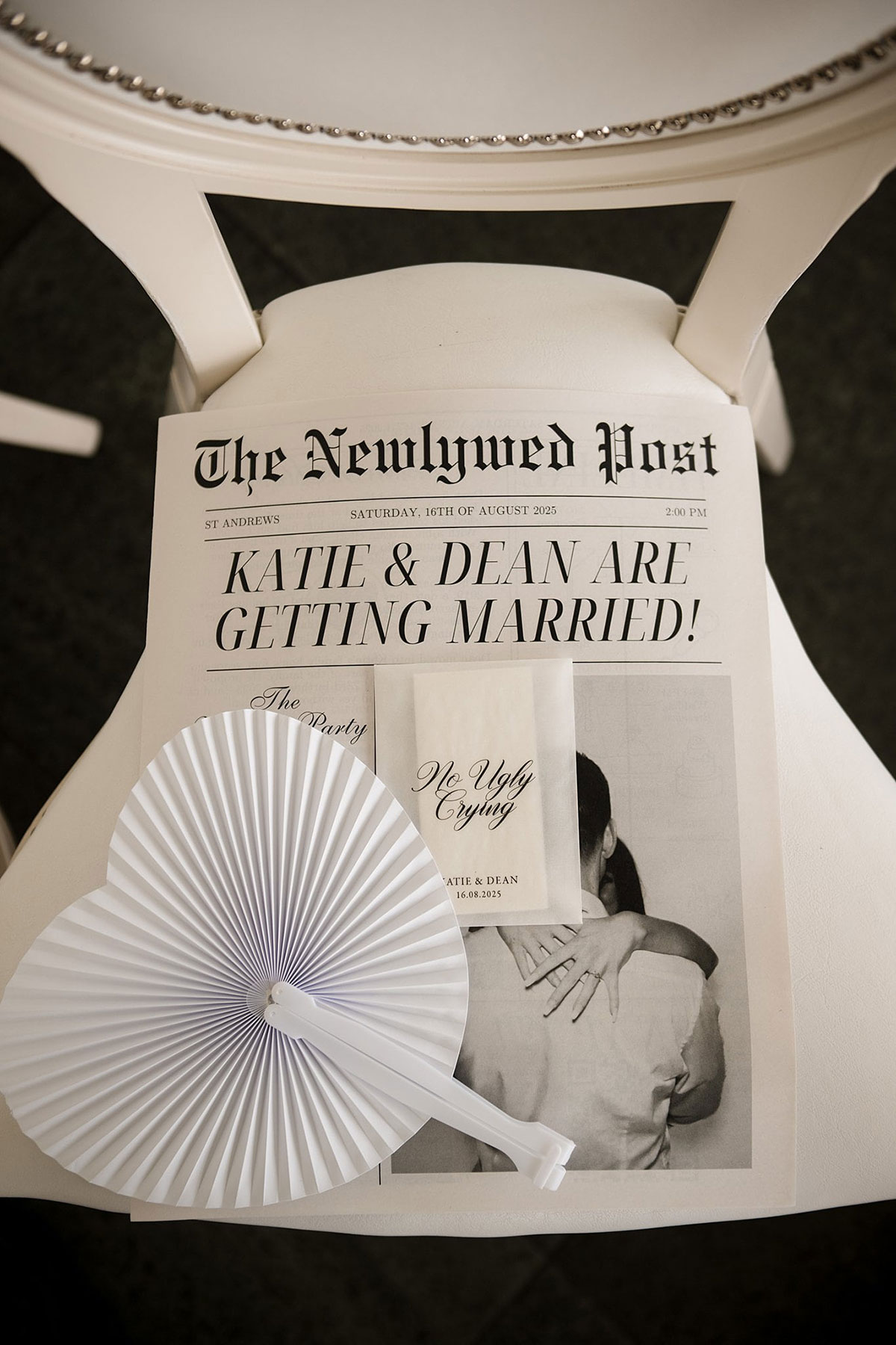 Personalised wedding newspaper and “no ugly crying” tissue pack placed on ceremony chair at Old Course Hotel wedding in St Andrews.