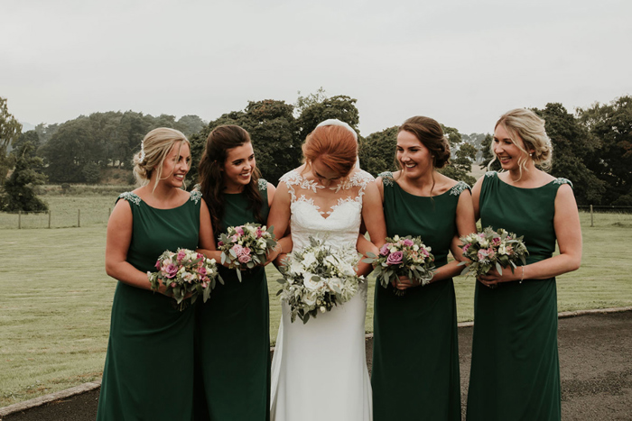 A Bride Laughing With 4 Bridesmaids Wearing Green Dresses