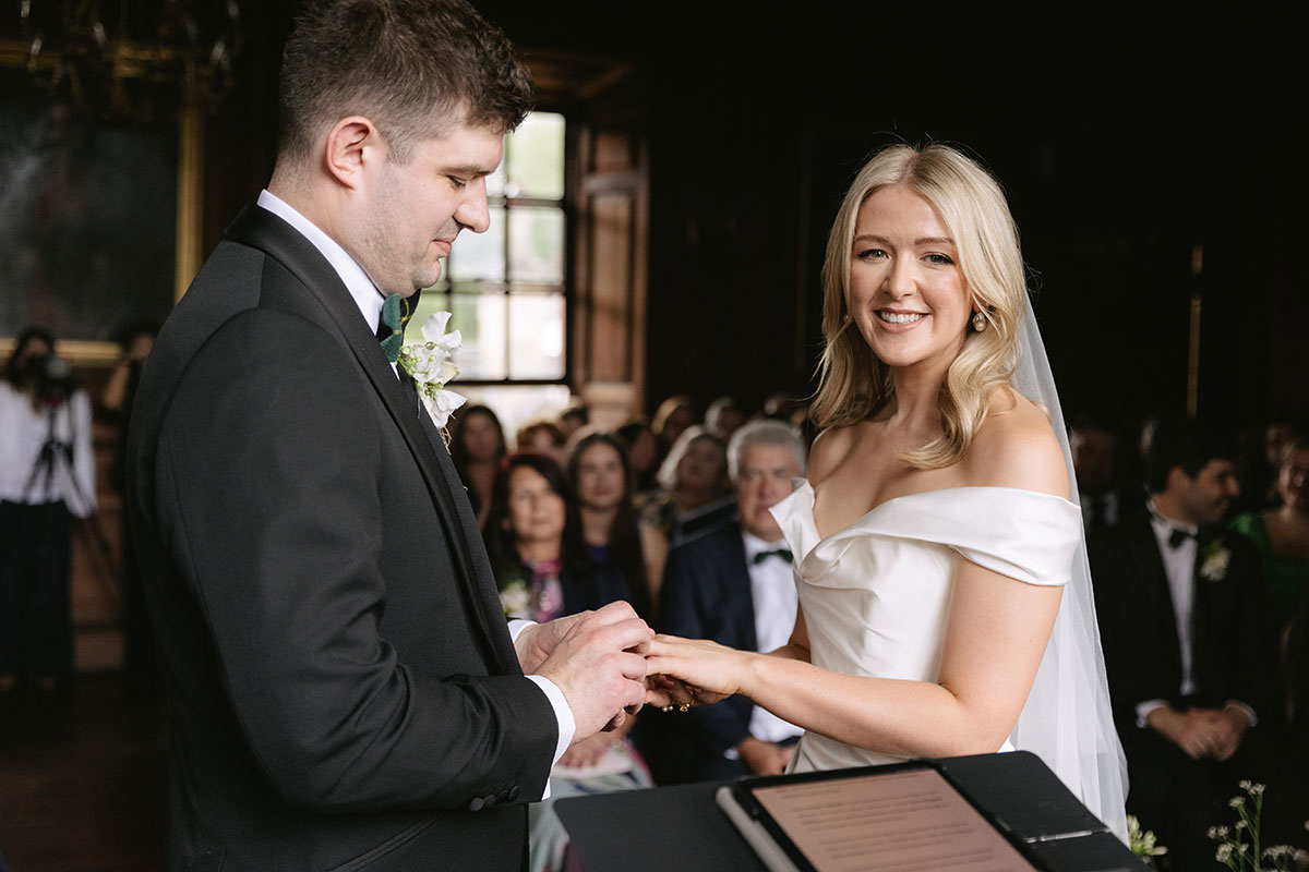 Bride and groom exchanging rings during indoor ceremony at Gilmerton House East Lothian