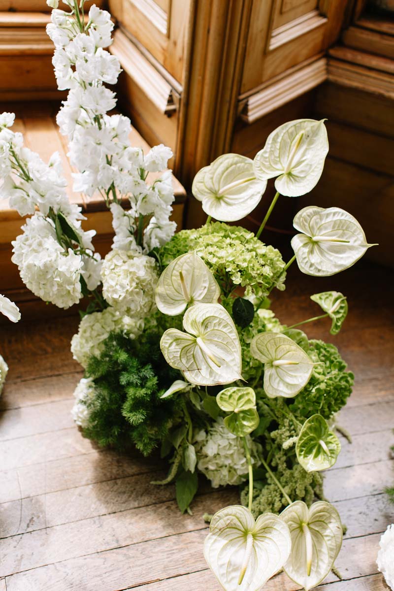 White and green wedding flower arrangement with anthuriums and hydrangeas decorating the ceremony space at Cambo House in Fife.