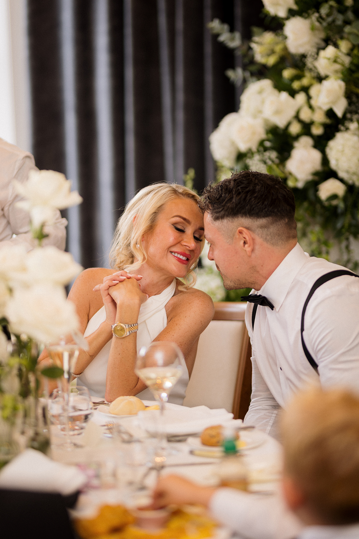 Bride and groom sharing a quiet moment at their wedding reception table