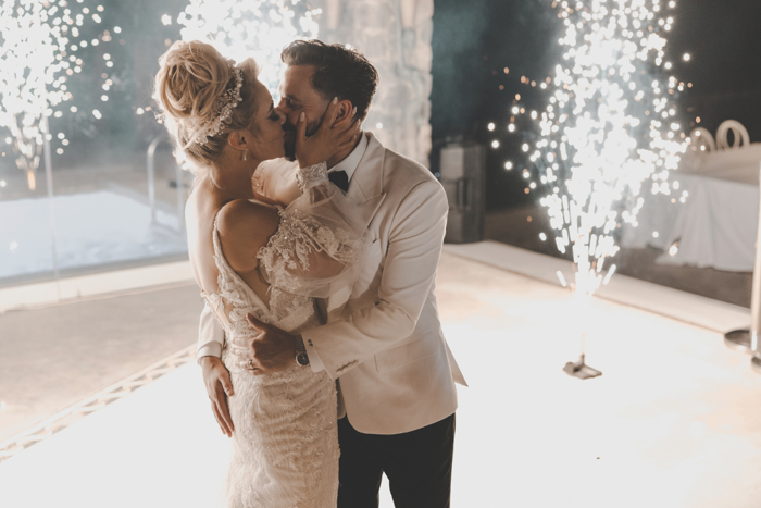 bride and groom kissing on dancefloor surrounded by sparklers