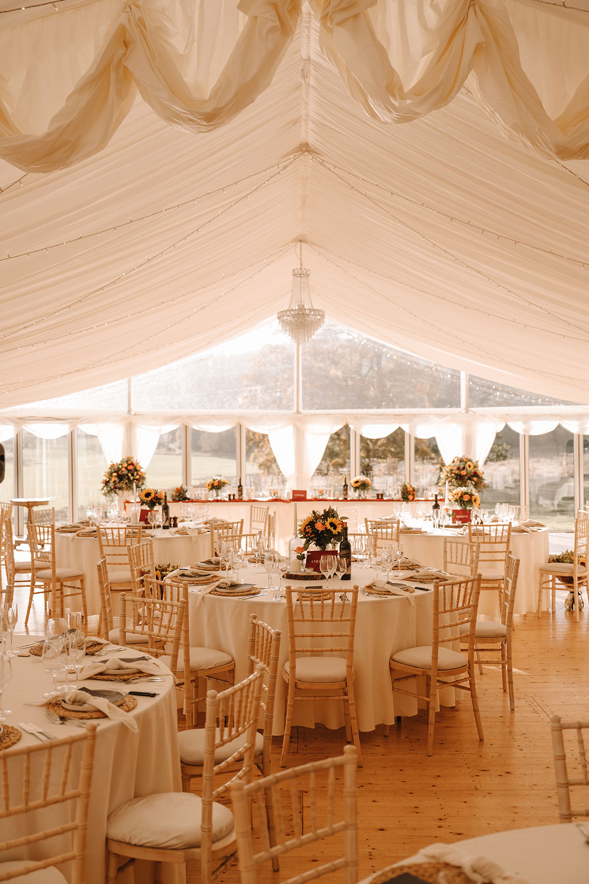 Tables set with white tablecloths and sunflower bouquets
