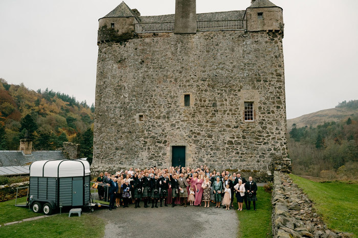a large group of people gathered for a photo outside Neidpath Castle