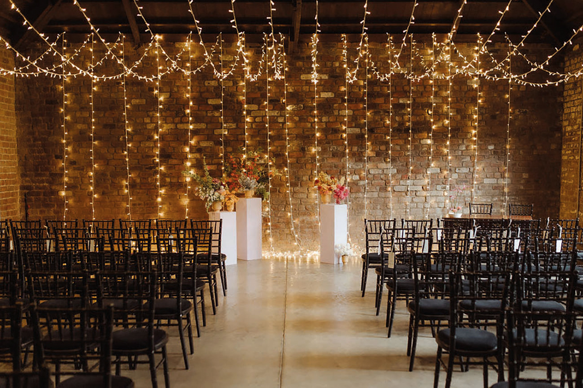 Industrial wedding ceremony setup with fairy lights and exposed brick at The Engine Works Glasgow