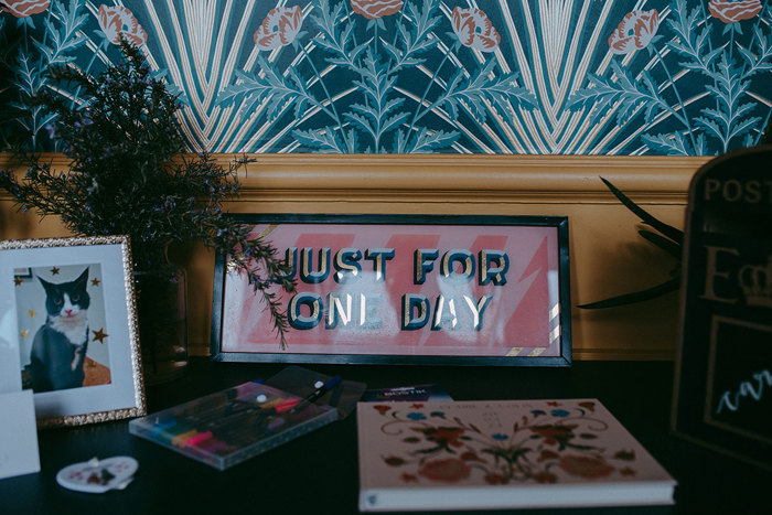 a pink sign reading 'Just For One Day' sitting on a table with guest book and pictures