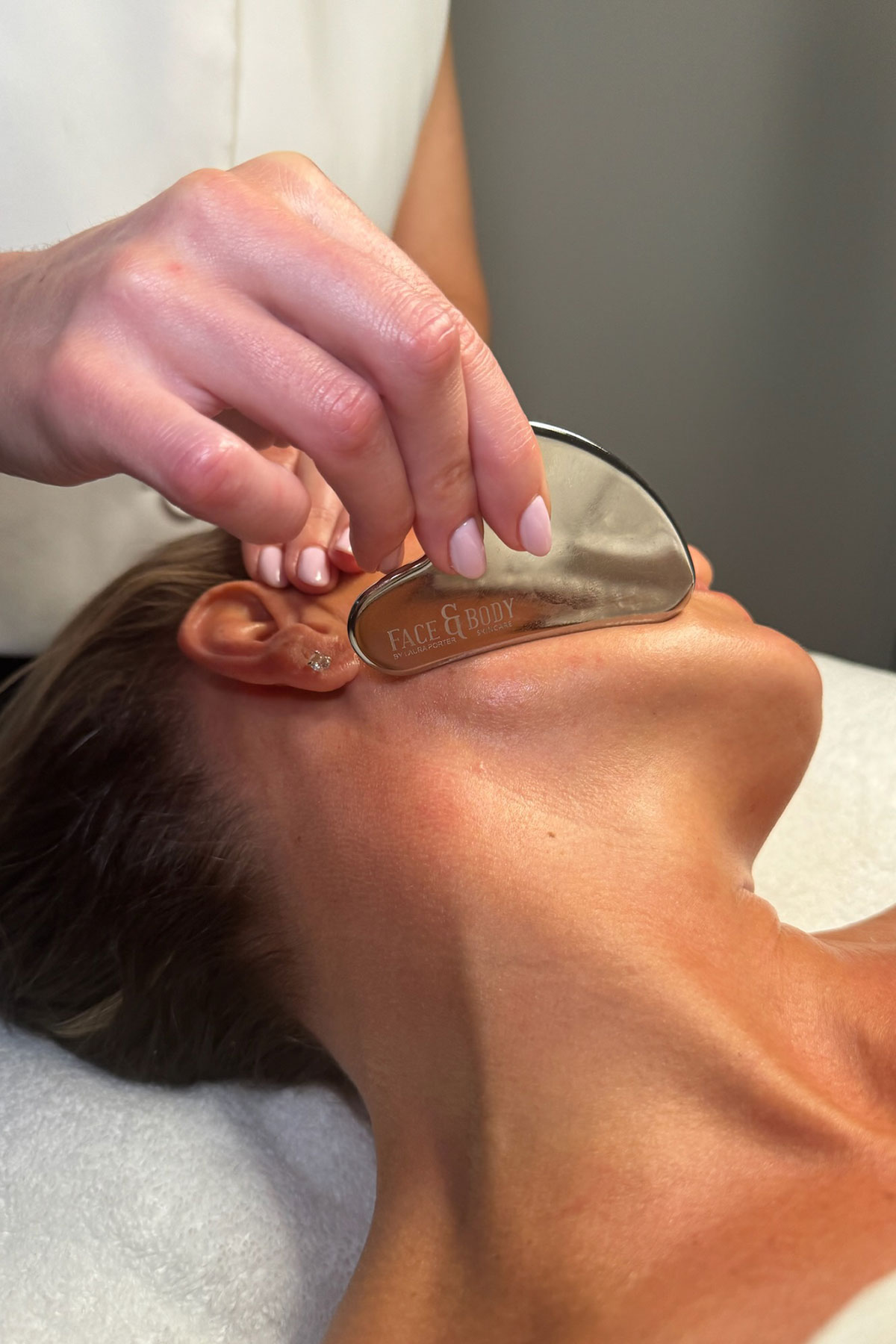 Metal gua sha tool being used during a sculpting facial treatment at FAB Salons Glasgow.