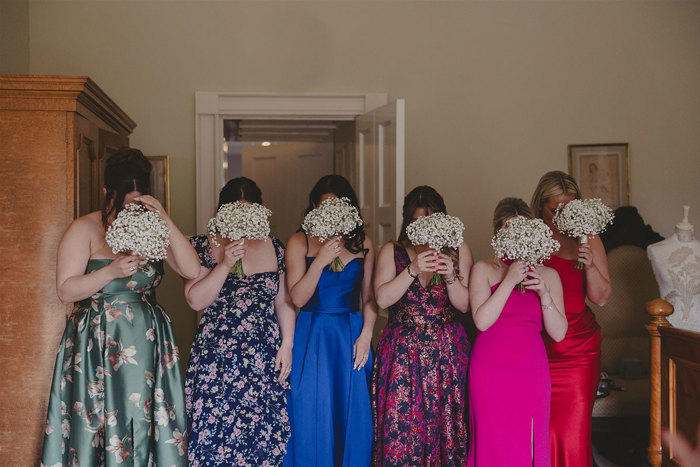 A group of women holding flowers in their faces