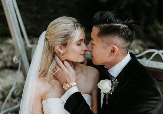 a bride and groom posing nose-to-nose for a wedding photo