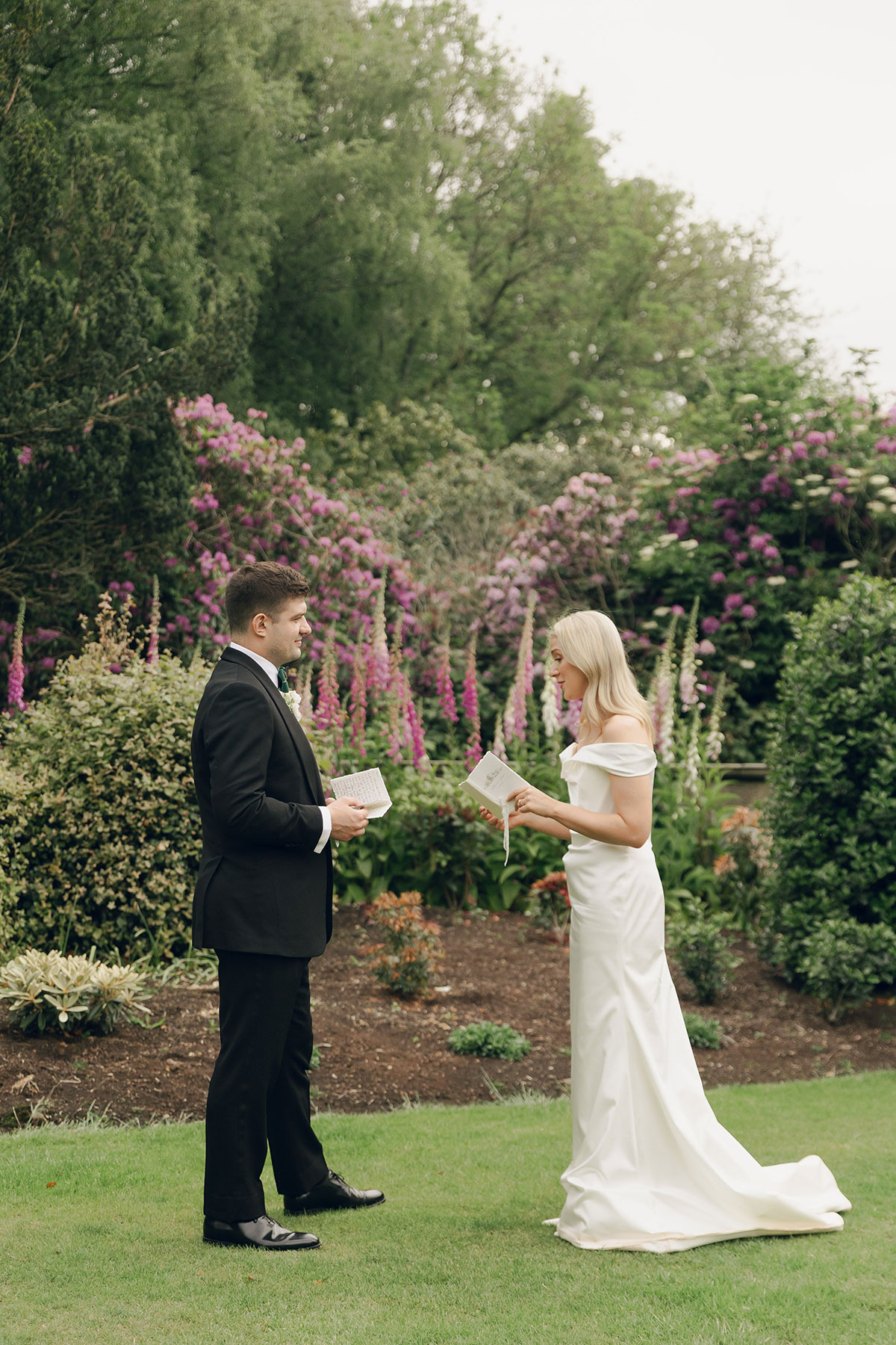 Bride and groom reading private vows in garden at Gilmerton House East Lothian wedding