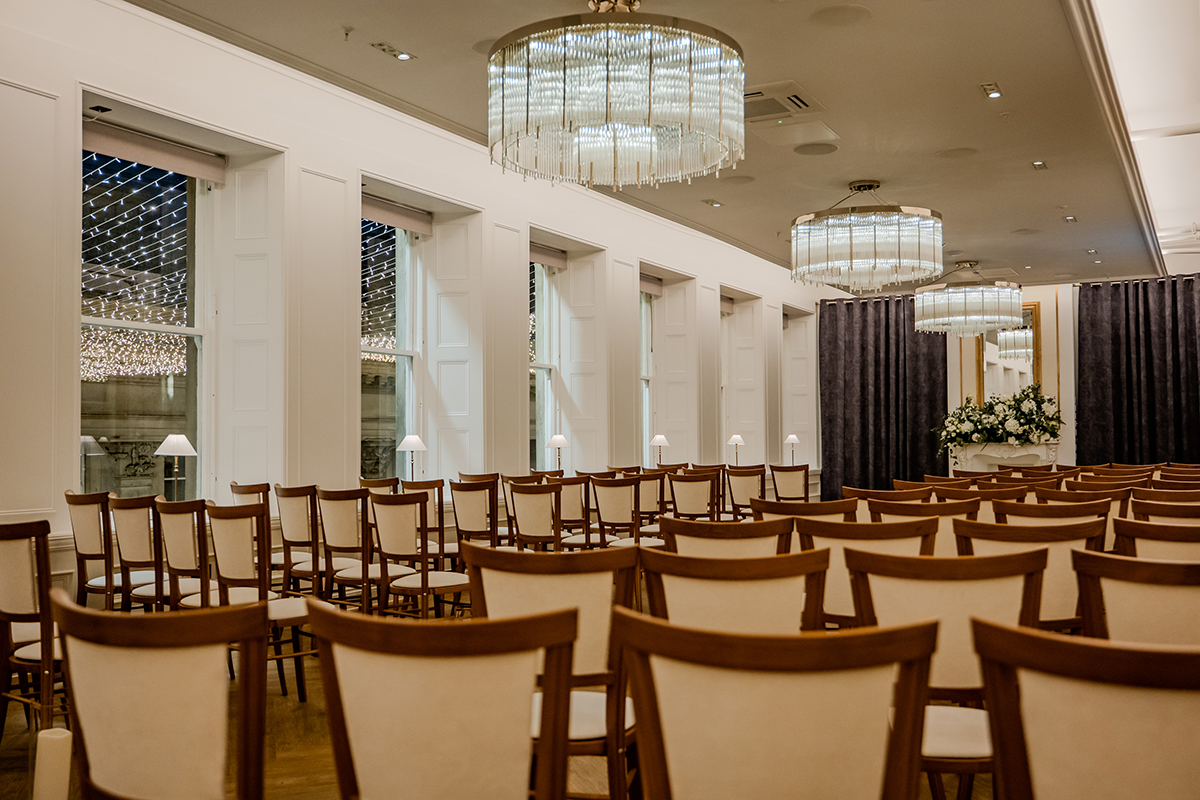 Ceremony room at The Exchange Glasgow with chandeliers and fairy lights outside the windows